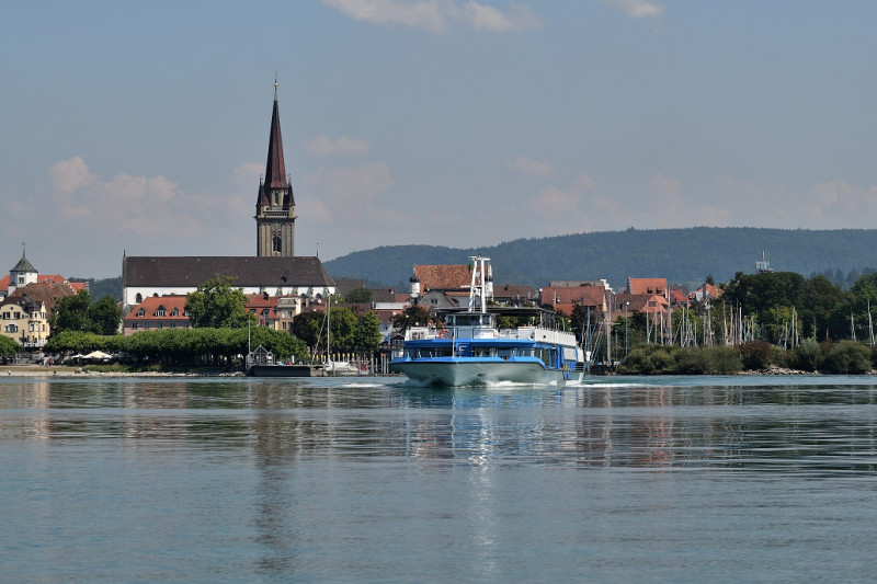Schiff auf dem Bodensee, Radolfzell im Hintergrund. Kirche und Häuser am Ufer. Urlaub am See.