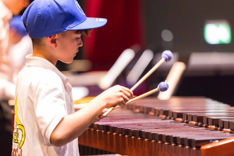 Junge spielt Xylophon. Musikinstrument, Konzert, Musiker mit Schlägel.