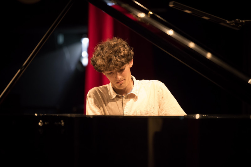 Junger Pianist spielt Klavier. Konzert, Musik, Musiker.