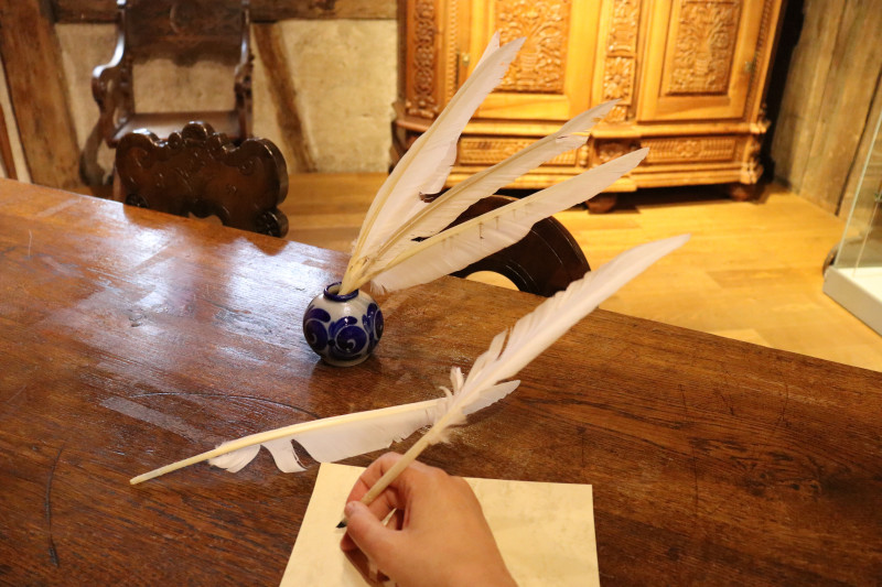 Federkiel und Tinte auf Tisch. Schreiben mit Feder. Historische Schreibkunst, alte Feder.